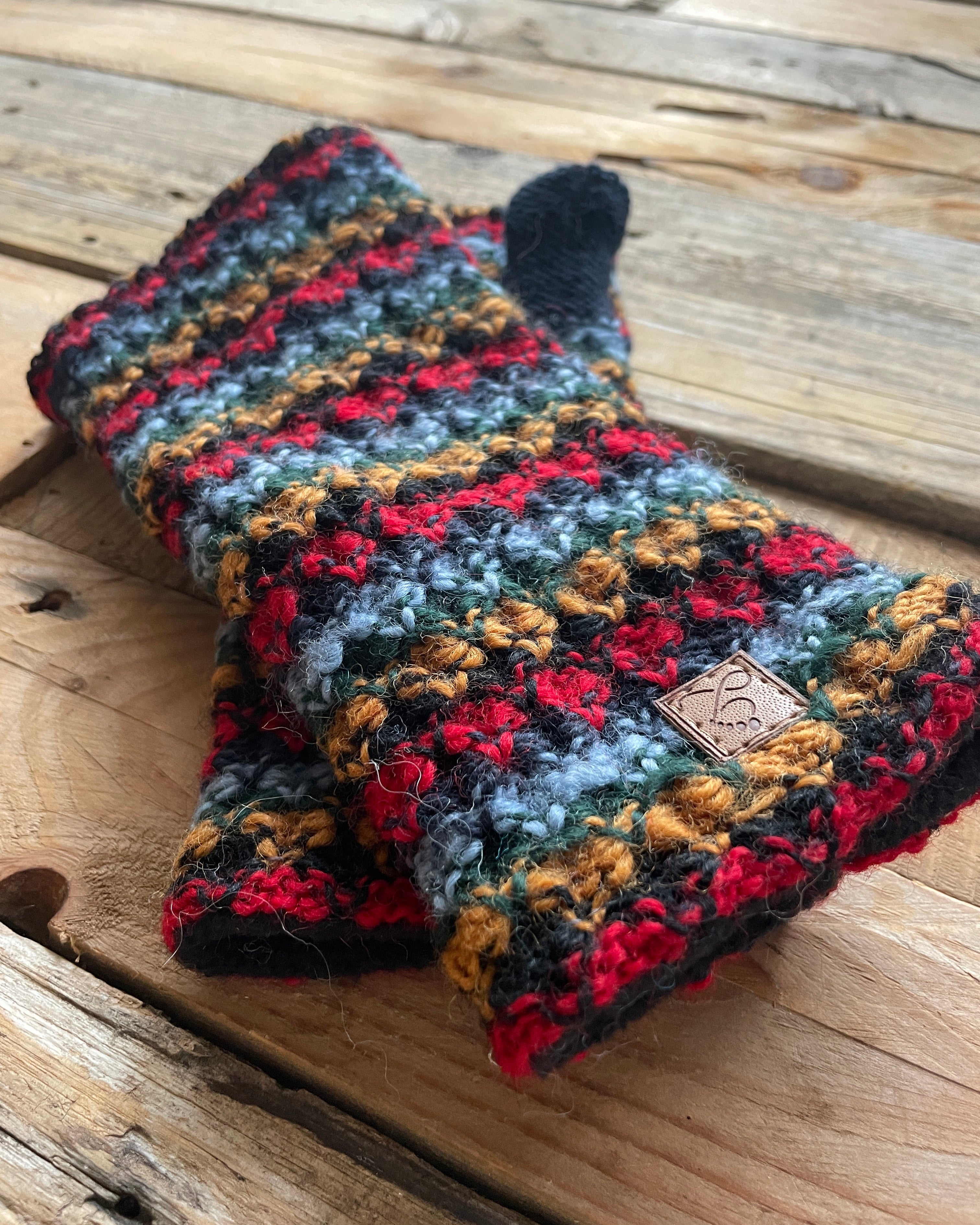 Multicolored knitted gloves on a wooden surface
