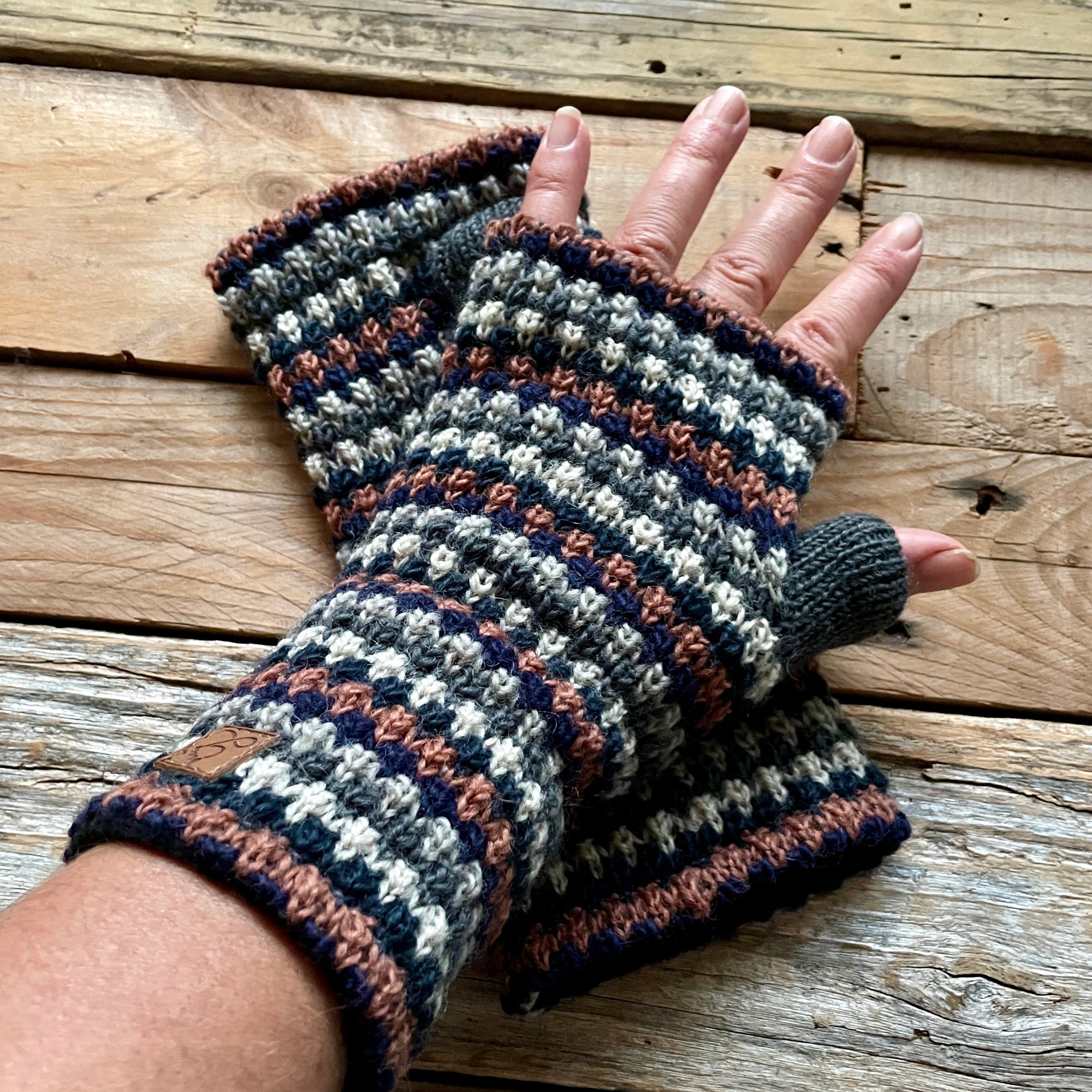 Handmade knitted fingerless gloves on a wooden surface