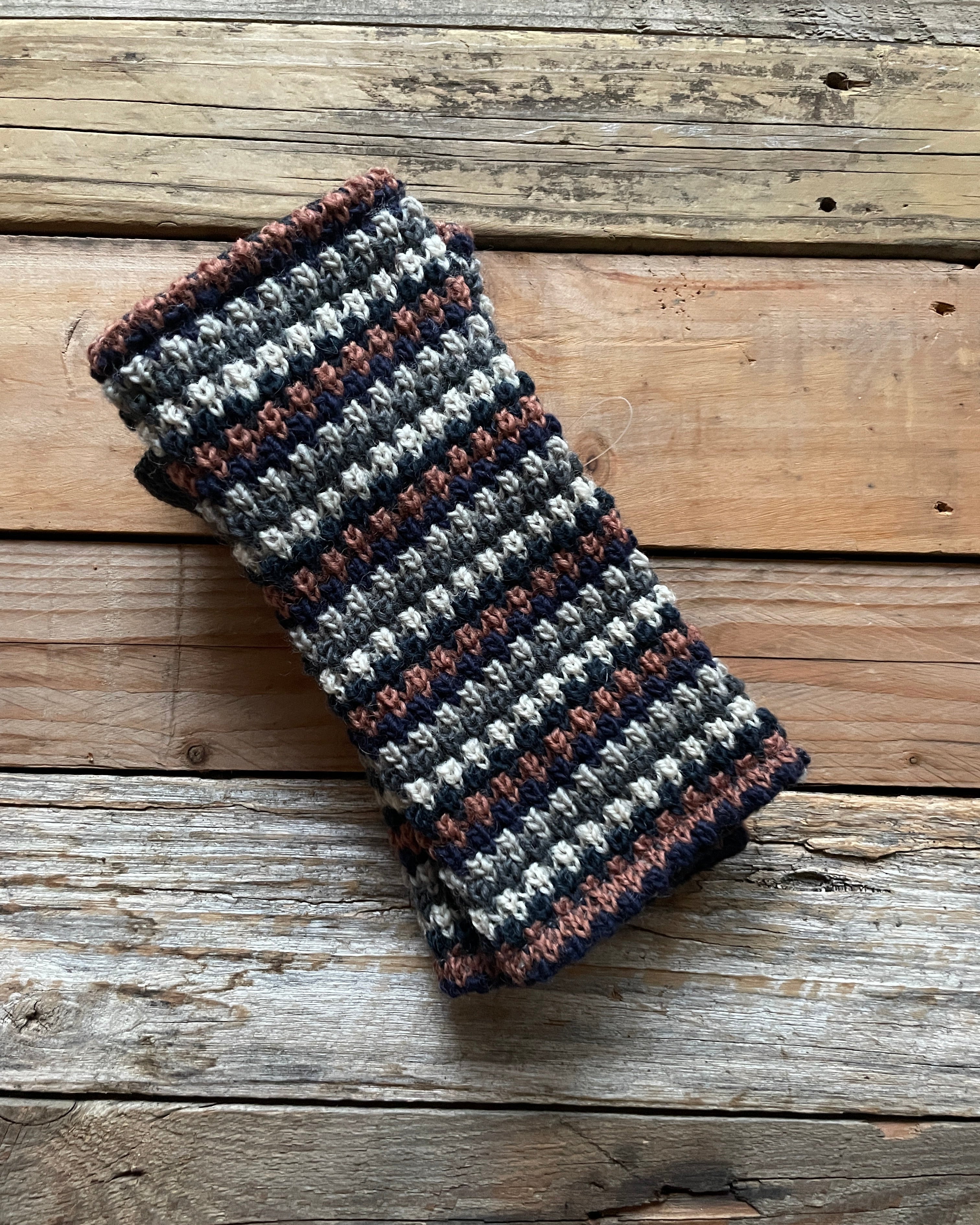 Handmade knitted fingerless gloves on a wooden surface