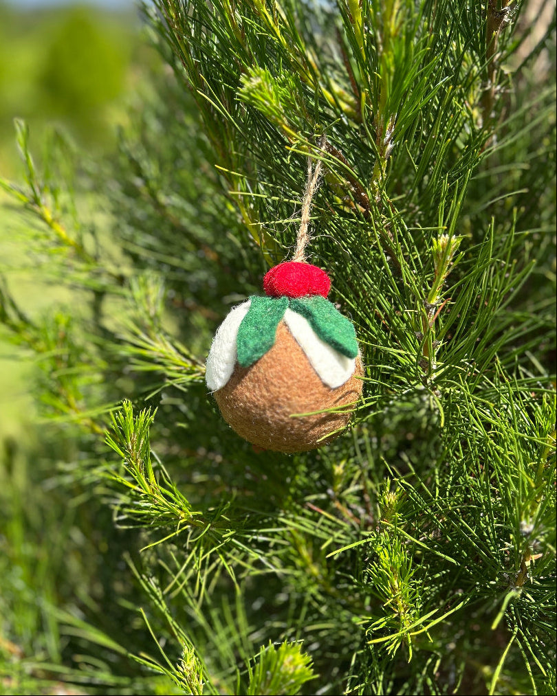 Felted ornament of plum pudding hanging on a tree