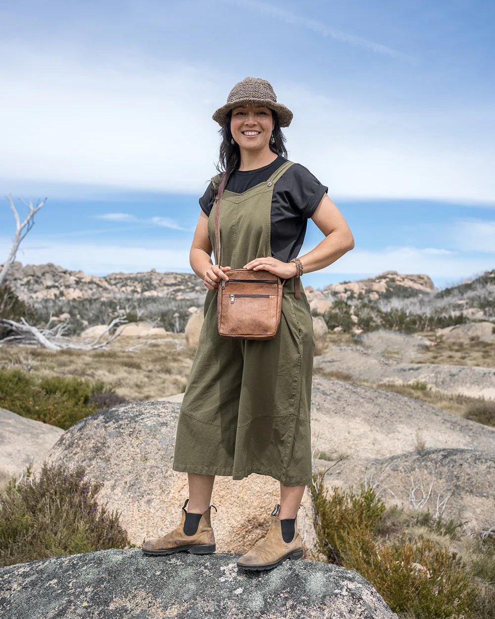 Woman standing on a rocky outcrop with a scenic background