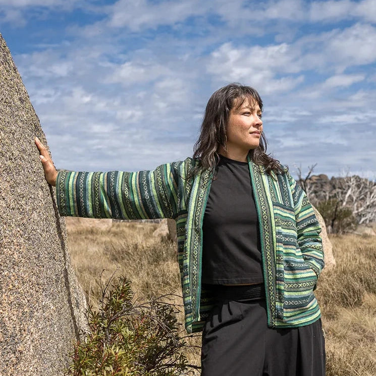 Person standing outdoors in a striped jacket