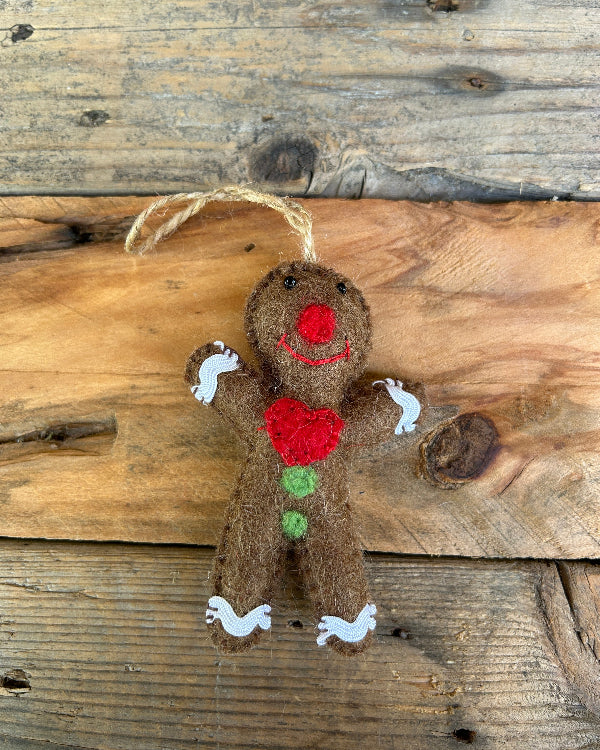 Gingerbread man ornament with a heart on a wooden background