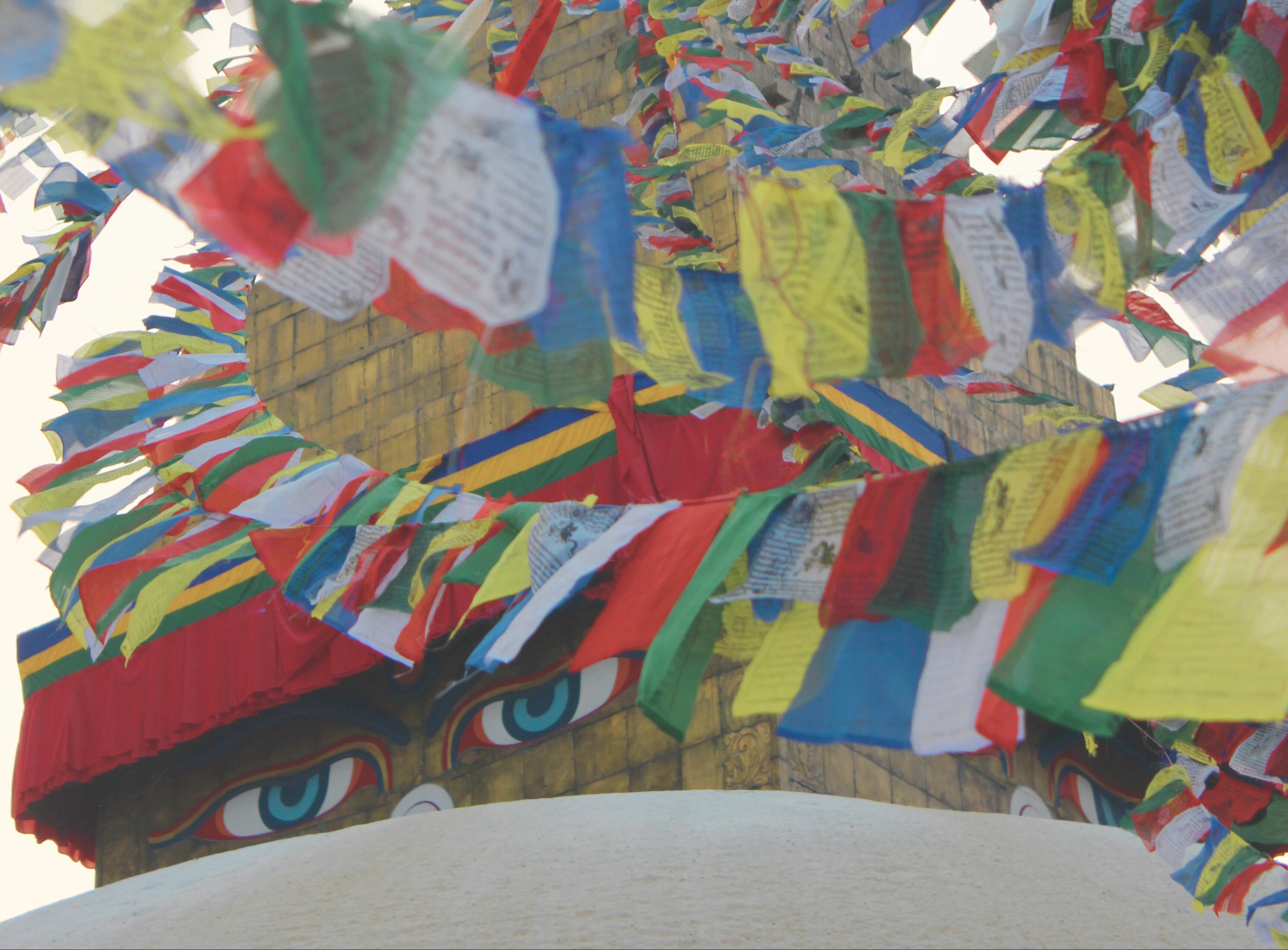 Colorful prayer flags in front of a traditional stupa in Nepal.