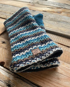 Pair of striped knit fingerless gloves on a wooden surface