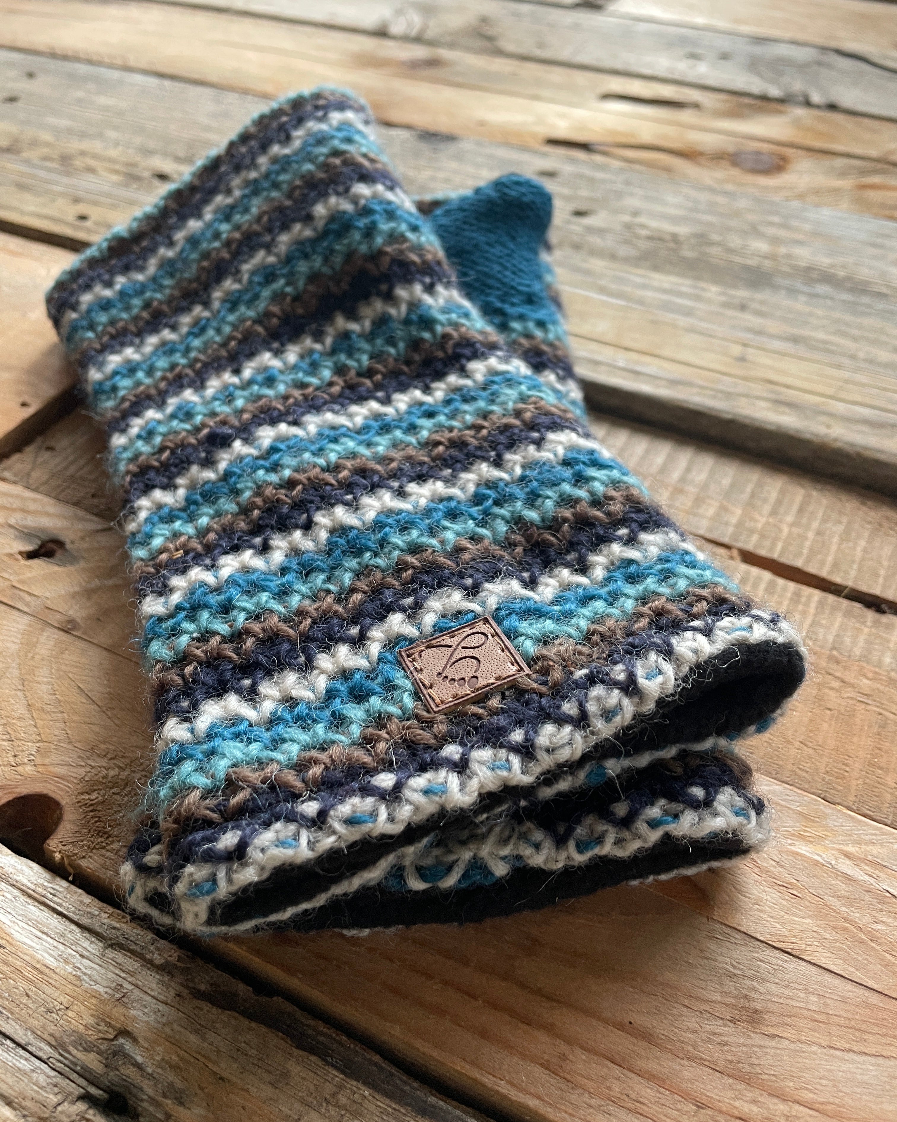 Pair of striped knit fingerless gloves on a wooden surface