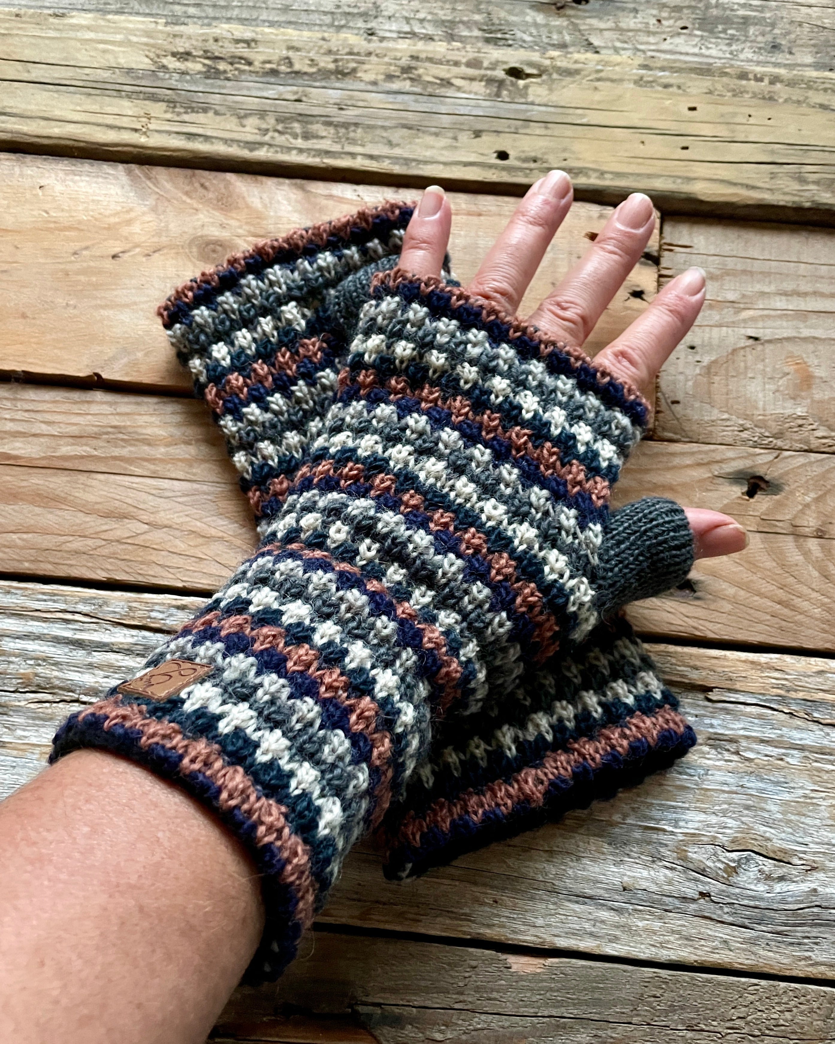 Handmade knitted fingerless gloves on a wooden surface
