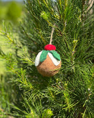 Felted ornament of plum pudding hanging on a tree