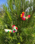 Colorful rooster ornaments hanging on a tree branch