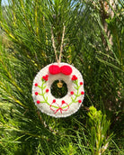 Decorative wreath ornament hanging on a tree with green leaves