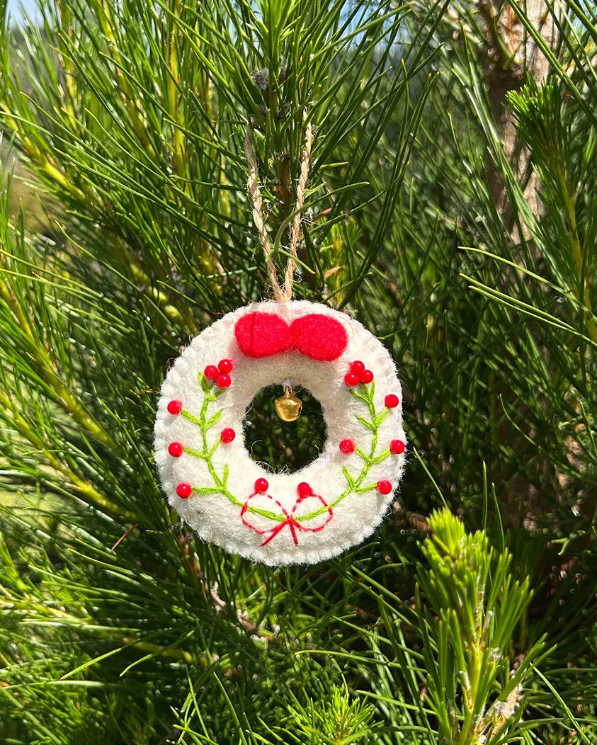 Decorative wreath ornament hanging on a tree with green leaves