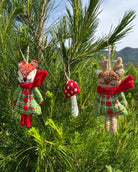 Decorative Christmas ornaments on a tree with a scenic background
