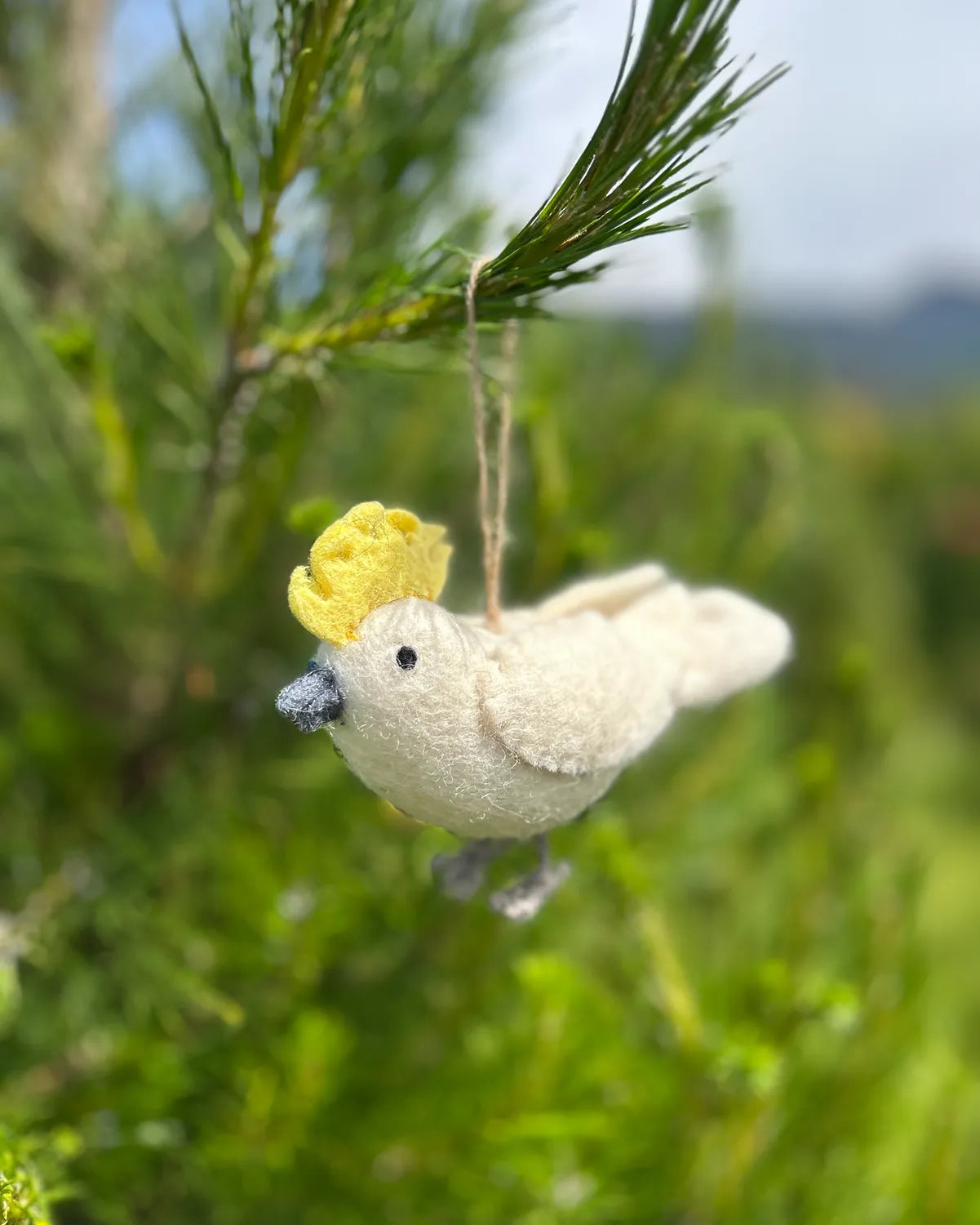 Cockatoo bird ornament with yellow flower on a branch