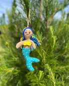 Mermaid ornament with blue tail and yellow top hanging on a tree