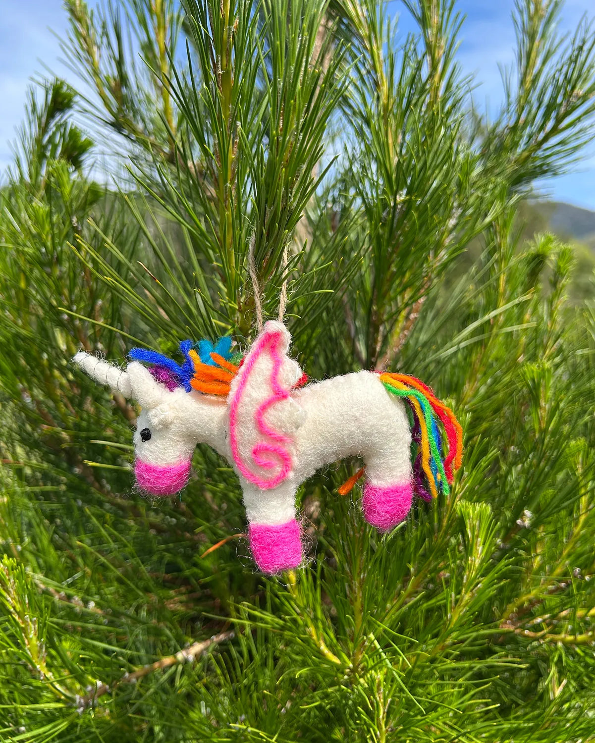 Colorful unicorn ornament hanging in a tree