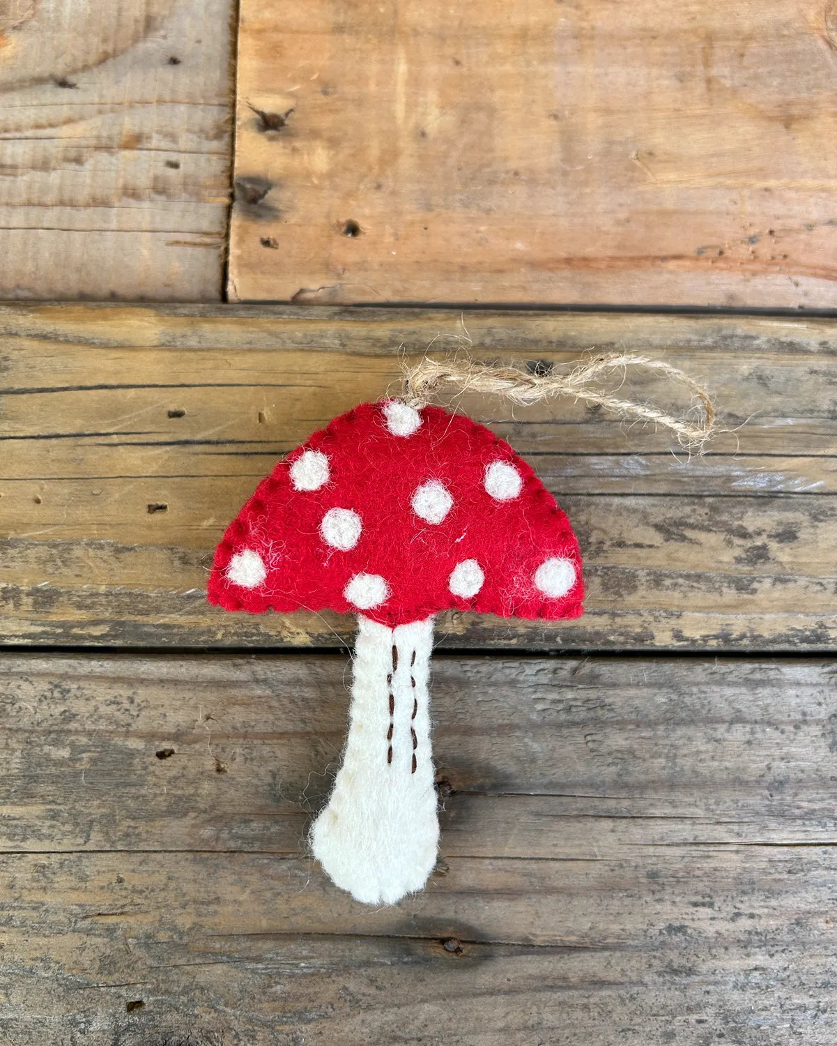 Decorative mushroom ornament with red cap and white polka dots on a wooden background