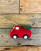 Red felt car ornament with christmas tree on a wooden surface