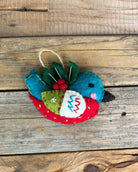 Felt ornament shaped like a bird with a red belly on a wooden surface