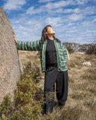Person standing in a natural landscape with a blue sky and clouds