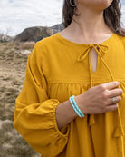 Person wearing a yellow top with a scenic background