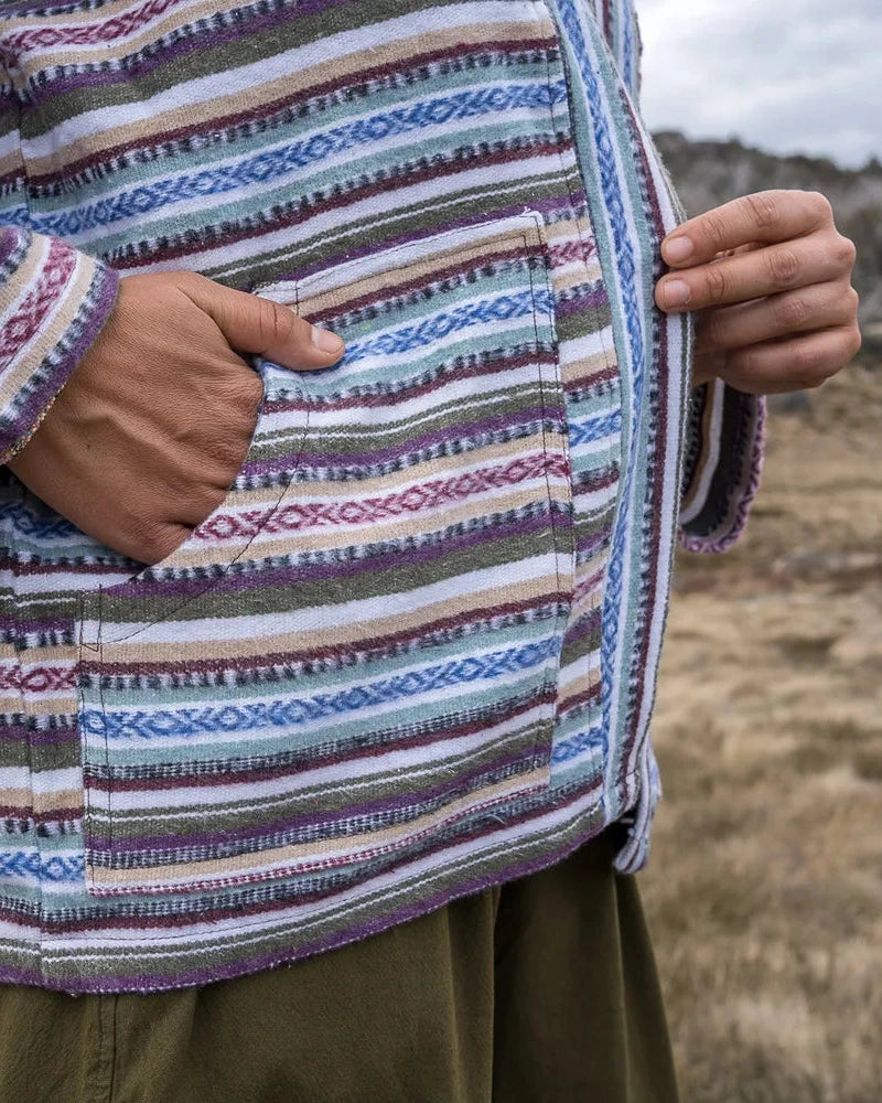 Person wearing a colorful striped jacket in a natural setting