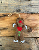 Gingerbread man ornament with a heart on a wooden background